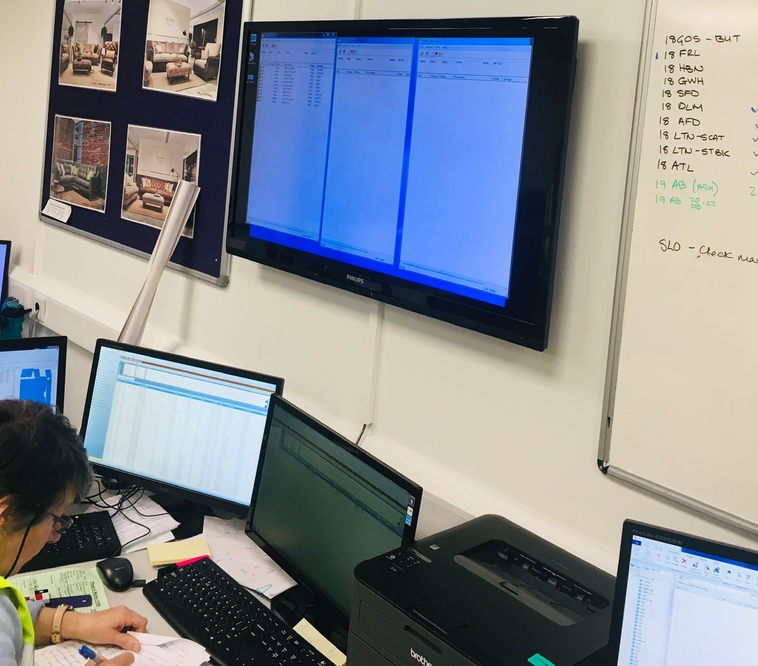 A production planning board and screens in the factory office